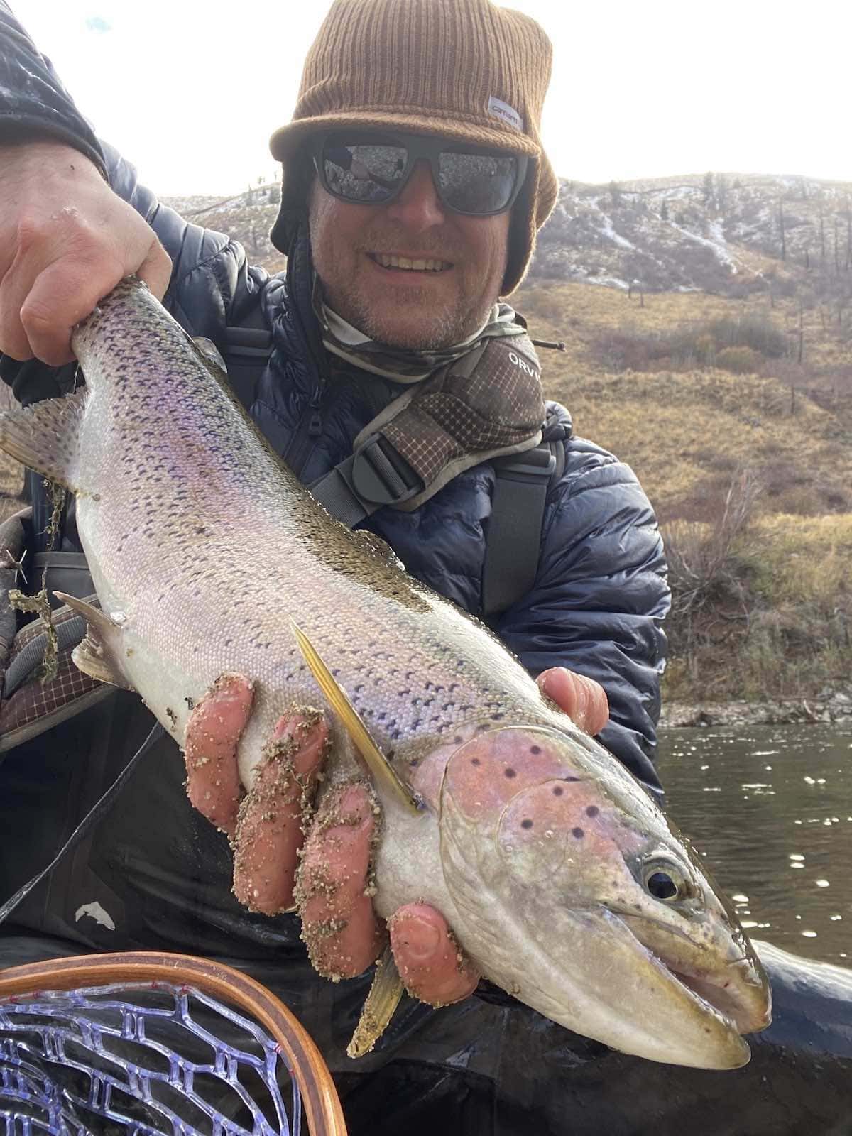 Big fish caught with net while fly fishing on river