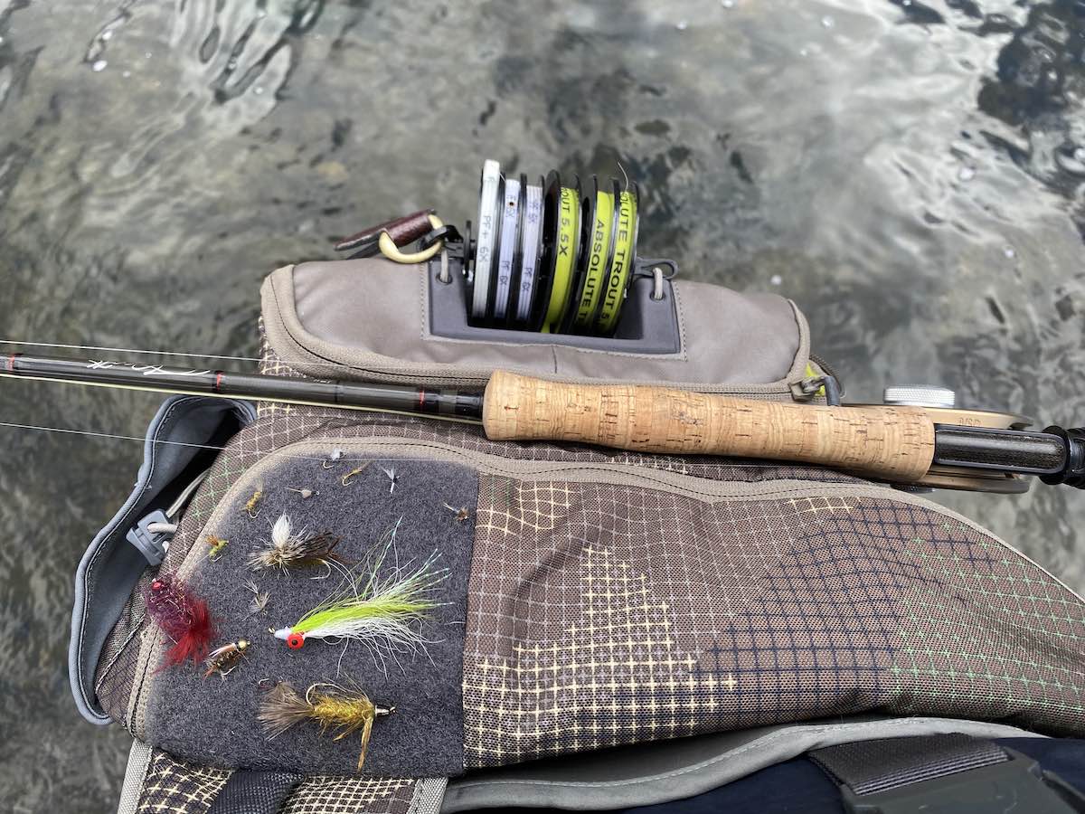Fly rod laying across fishing slingpack on the water